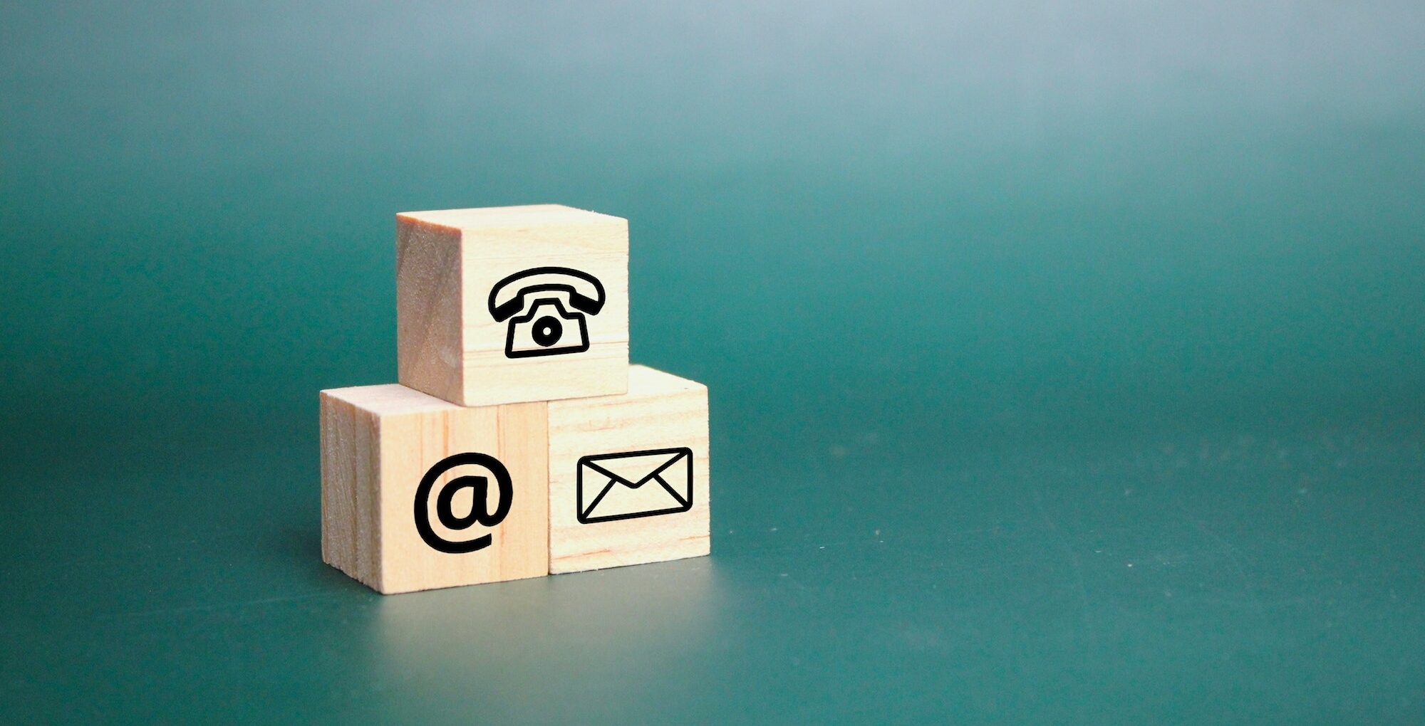 three wooden cubes with contact icons.